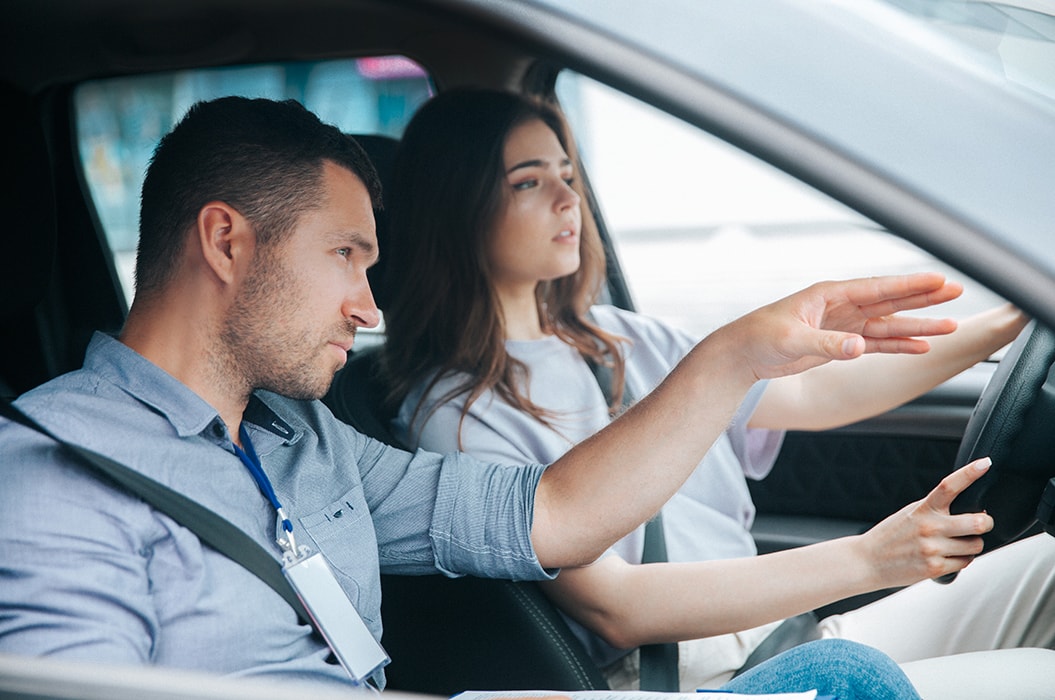 Fahrlehrer mit Schülerin im Auto